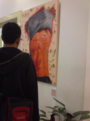 Seorang pengunjung mengamati salah satu lukisan Ideologi Perut, pada pameran seni rupa di Balai Soedjadmoko, Solo Balai Soedjatmoko, Rabu (25/9) Malam. | HARIANSOLO - Ita Purwati